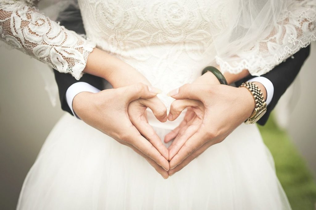 para nowożeńców ich dłonie ułożone w kształt serc